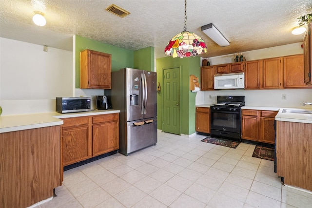 17006 Dusty Mill Dr E, Sugar Land, TX 77498 - kitchen featuring stainless steel appliances, brown cabinets, a textured ceiling, light countertops, and decorative light fixtures