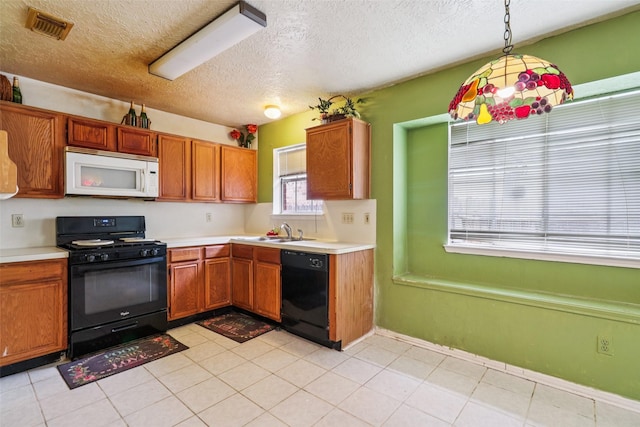 17006 Dusty Mill Dr E, Sugar Land, TX 77498 - kitchen featuring black appliances, light countertops, a textured ceiling, brown cabinets, and pendant lighting