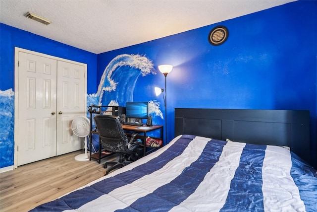 17006 Dusty Mill Dr E, Sugar Land, TX 77498 - bedroom featuring wood finished floors, a closet, and a textured ceiling