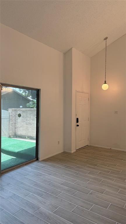 12922 Wirevine Ln, Houston, TX 77072 - spare room featuring wood tiled floors and vaulted ceiling