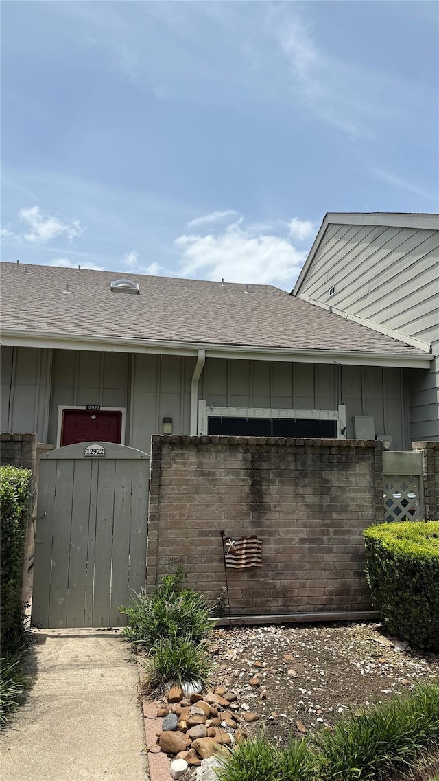 12922 Wirevine Ln, Houston, TX 77072 - view of exterior entry with board and batten siding and a shingled roof