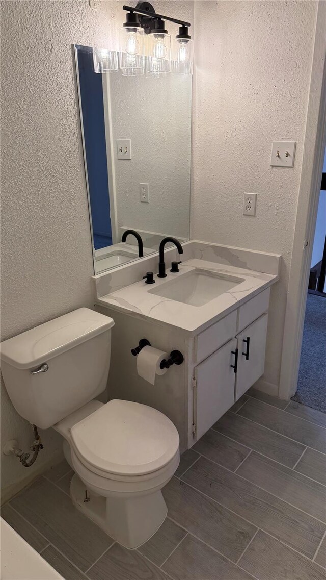 12922 Wirevine Ln, Houston, TX 77072 - half bathroom featuring vanity, a textured wall, and wood finish floors