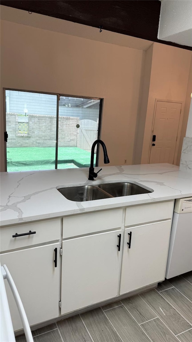 12922 Wirevine Ln, Houston, TX 77072 - kitchen with dishwasher, white cabinetry, light stone countertops, and wood finish floors
