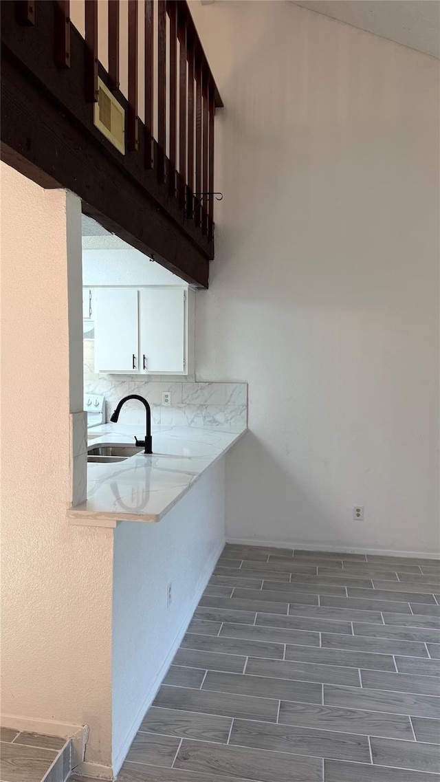 12922 Wirevine Ln, Houston, TX 77072 - kitchen with wood finished floors, white cabinets, light countertops, and decorative backsplash