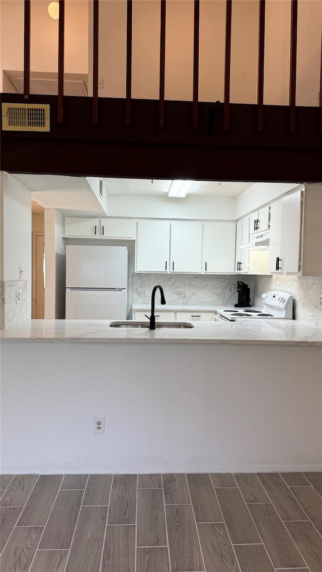12922 Wirevine Ln, Houston, TX 77072 - kitchen featuring white appliances, light countertops, wood finish floors, tasteful backsplash, and white cabinets