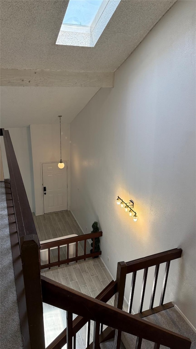 12922 Wirevine Ln, Houston, TX 77072 - staircase featuring vaulted ceiling, a skylight, carpet floors, and a textured ceiling