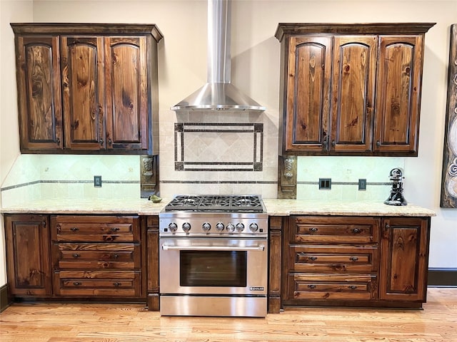 1241 W 24th St Unit C, Houston, TX 77008 - kitchen with high end range, wall chimney range hood, backsplash, and dark brown cabinets