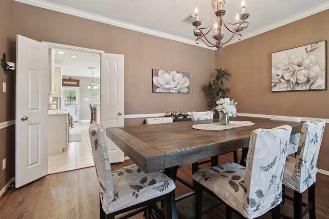 12103 Via San Rocco Ct, Cypress, TX 77429 - dining area featuring a chandelier, ornamental molding, and wood finished floors