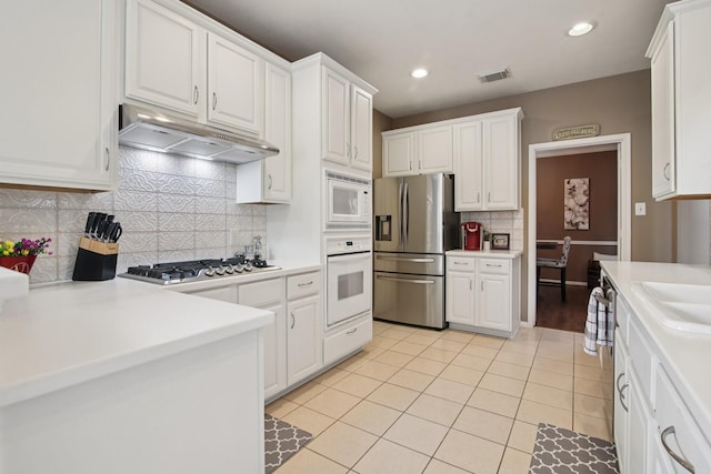 12103 Via San Rocco Ct, Cypress, TX 77429 - kitchen featuring appliances with stainless steel finishes, extractor fan, light tile patterned floors, white cabinetry, and backsplash