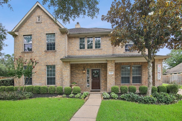 12103 Via San Rocco Ct, Cypress, TX 77429 - traditional home featuring a front lawn, brick siding, a chimney, and a shingled roof