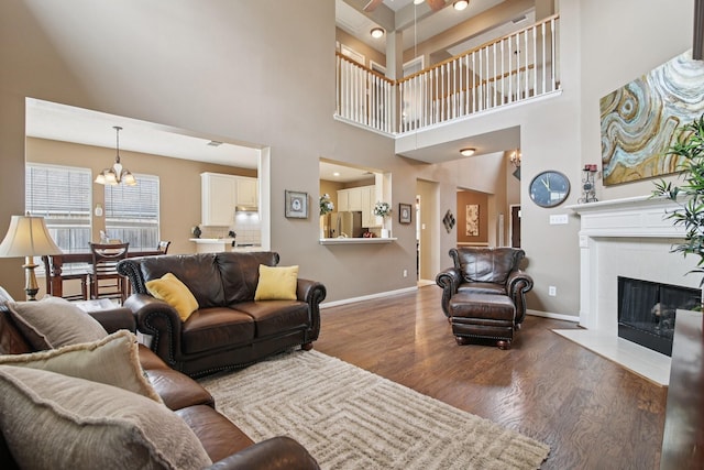 12103 Via San Rocco Ct, Cypress, TX 77429 - living area with a chandelier, wood finished floors, a tile fireplace, and a high ceiling