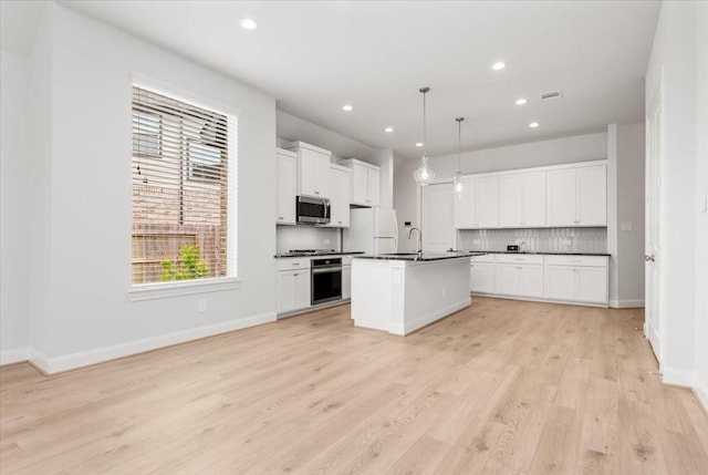 12831 Raemoir Dr, Humble, TX 77346 - kitchen featuring stainless steel appliances, dark countertops, decorative backsplash, light wood-style flooring, and recessed lighting