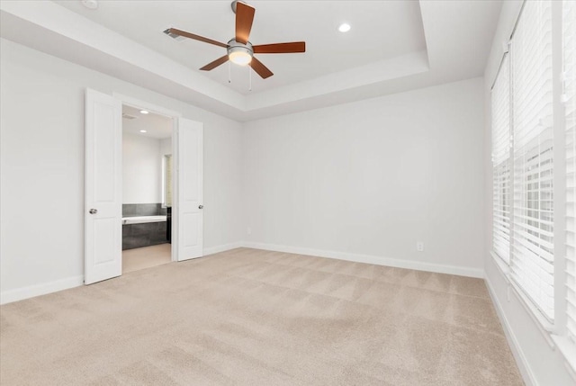12831 Raemoir Dr, Humble, TX 77346 - unfurnished bedroom with light carpet, recessed lighting, a tray ceiling, ensuite bath, and a ceiling fan
