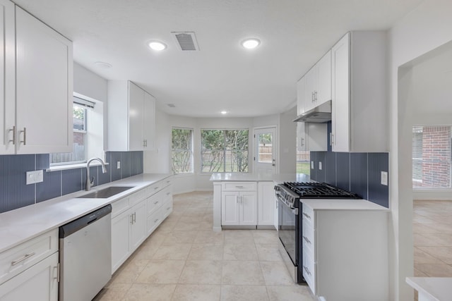 1815 Moston Dr, Spring, TX 77386 - kitchen with appliances with stainless steel finishes, under cabinet range hood, healthy amount of natural light, recessed lighting, and backsplash