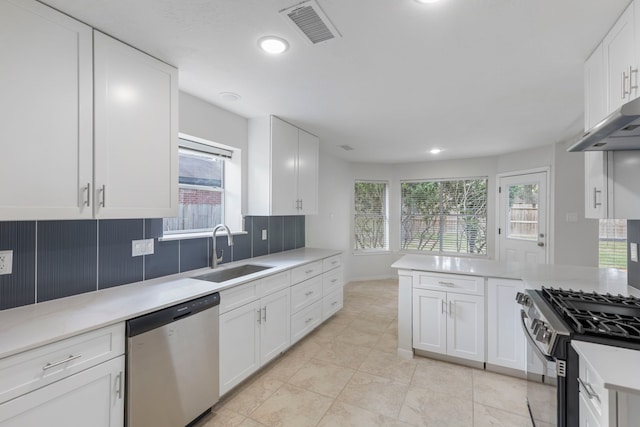1815 Moston Dr, Spring, TX 77386 - kitchen with appliances with stainless steel finishes, light countertops, white cabinetry, light tile patterned floors, and recessed lighting