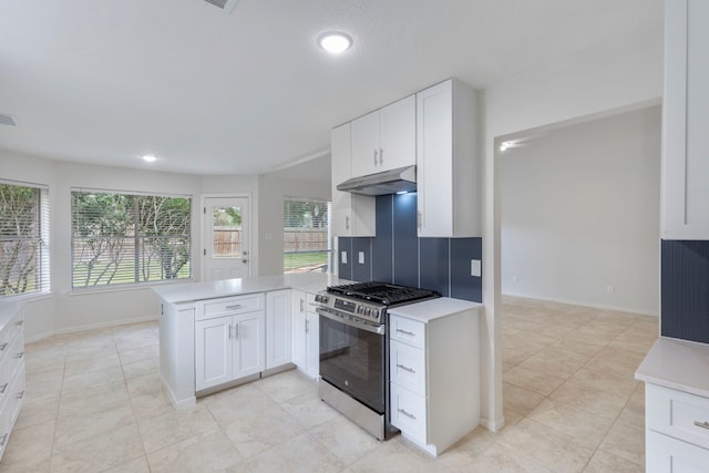1815 Moston Dr, Spring, TX 77386 - kitchen featuring gas stove, under cabinet range hood, a peninsula, light countertops, and white cabinetry