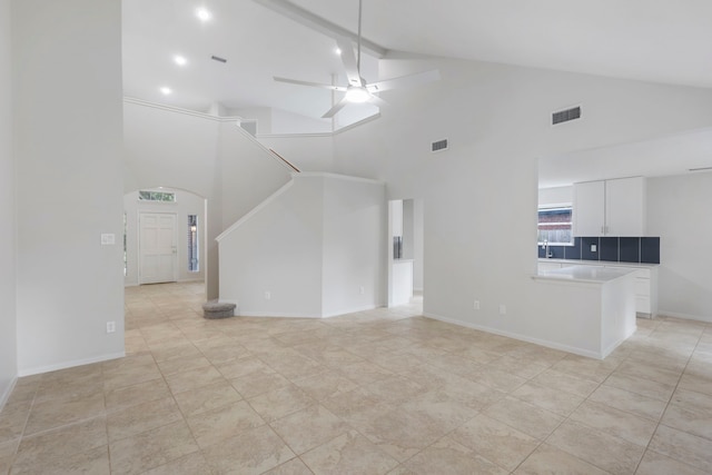 1815 Moston Dr, Spring, TX 77386 - unfurnished living room with high vaulted ceiling, ceiling fan, stairs, arched walkways, and light tile patterned floors