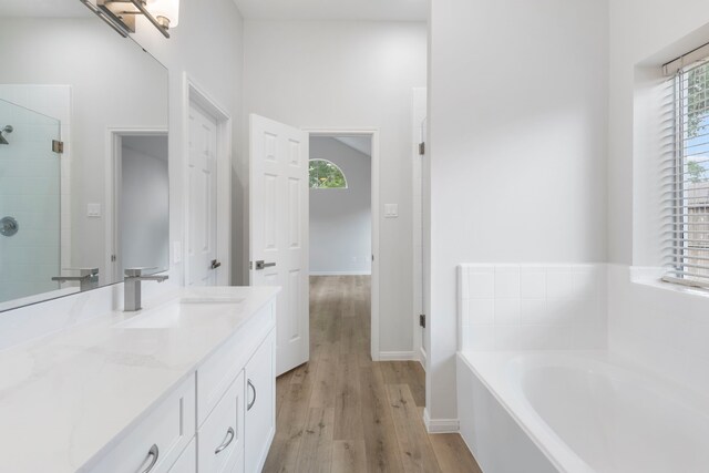 1815 Moston Dr, Spring, TX 77386 - full bathroom featuring vanity, healthy amount of natural light, a bath, and wood finished floors