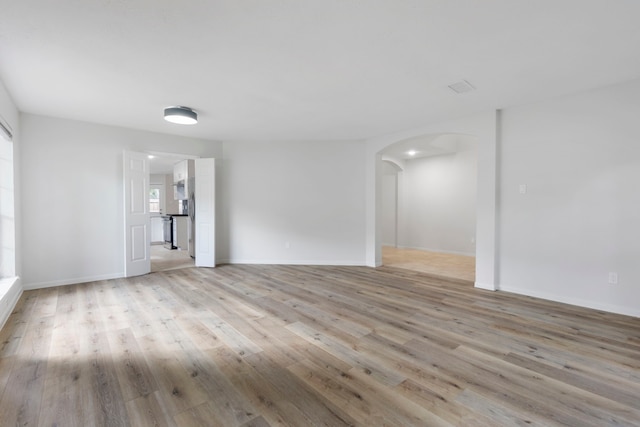 1815 Moston Dr, Spring, TX 77386 - spare room featuring light wood-style flooring and arched walkways