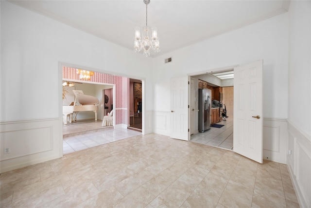 2701 11th St N, Texas City, TX 77590 - unfurnished room featuring a chandelier, a decorative wall, and a wainscoted wall