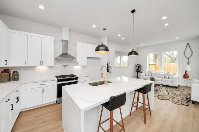 4415 Coke St Unit B, Houston, TX 77020 - kitchen featuring electric range, wall chimney range hood, light wood-style flooring, tasteful backsplash, and light stone countertops
