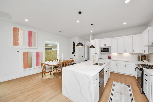 4415 Coke St Unit B, Houston, TX 77020 - kitchen with appliances with stainless steel finishes, light wood finished floors, pendant lighting, white cabinets, and recessed lighting