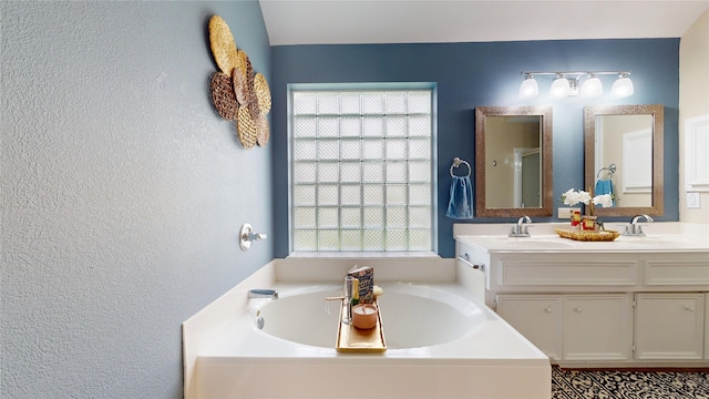 18118 Castle Rain Dr, Humble, TX 77346 - full bathroom featuring plenty of natural light, a garden tub, double vanity, a textured wall, and a stall shower