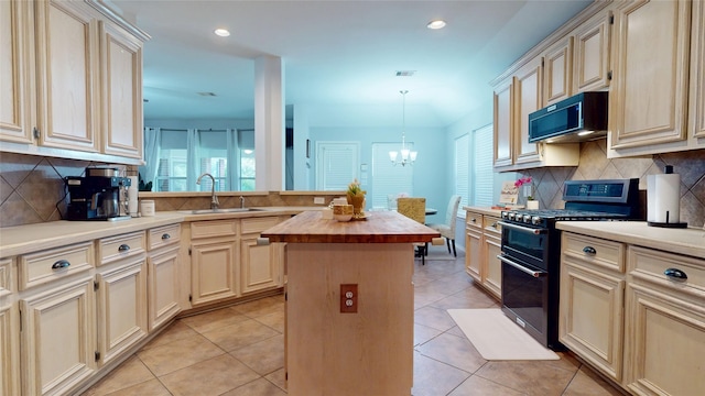 18118 Castle Rain Dr, Humble, TX 77346 - kitchen with range with two ovens, cream cabinetry, butcher block counters, a center island, and plenty of natural light