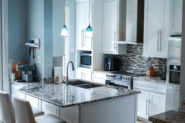 1620 Wellington Pl Unit 204, Beaumont, TX 77706 - kitchen featuring stainless steel appliances, wall chimney exhaust hood, white cabinets, tasteful backsplash, and a kitchen breakfast bar