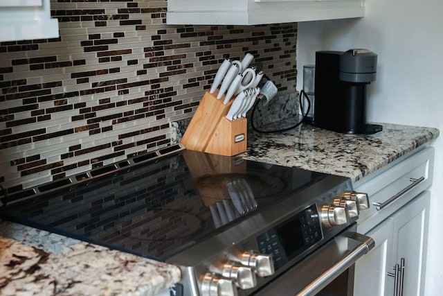 1620 Wellington Pl Unit 204, Beaumont, TX 77706 - kitchen view of decorative backsplash, light stone counters, and white cabinetry