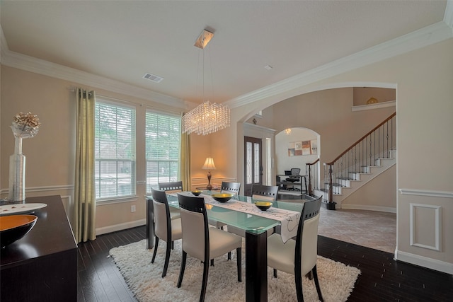 16011 Maple Shores Dr, Houston, TX 77044 - dining area with arched walkways, stairway, dark wood-style floors, ornamental molding, and a chandelier