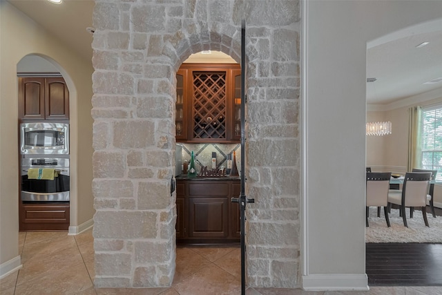 16011 Maple Shores Dr, Houston, TX 77044 - bar area with appliances with stainless steel finishes, arched walkways, light tile patterned floors, and a chandelier