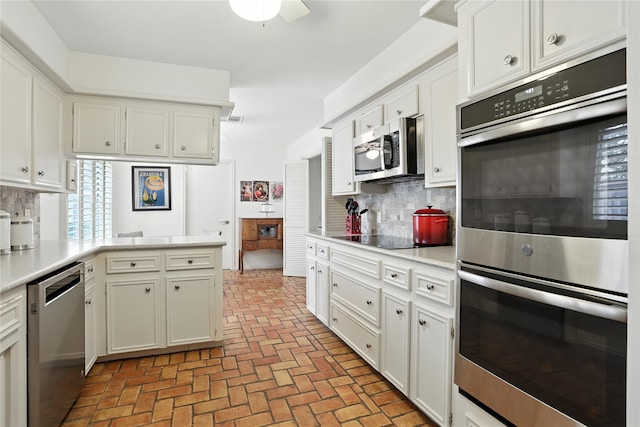2618 Fontana Dr, Houston, TX 77043 - kitchen featuring stainless steel appliances, light countertops, brick floors, and decorative backsplash