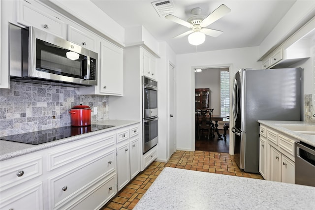 2618 Fontana Dr, Houston, TX 77043 - kitchen featuring appliances with stainless steel finishes, decorative backsplash, ceiling fan, light countertops, and white cabinetry
