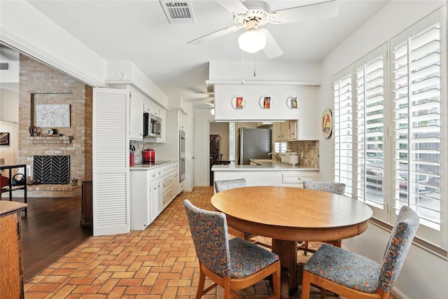 2618 Fontana Dr, Houston, TX 77043 - dining room with ceiling fan, a brick fireplace, and brick flooring