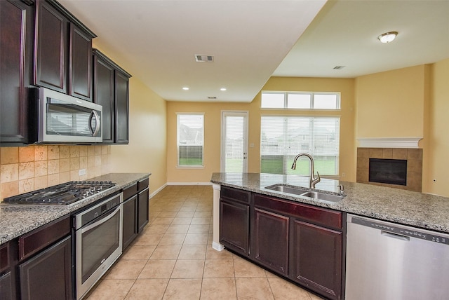 20315 Cypress Poll Dr, Cypress, TX 77433 - kitchen with stainless steel appliances, light tile patterned flooring, tasteful backsplash, light stone counters, and recessed lighting