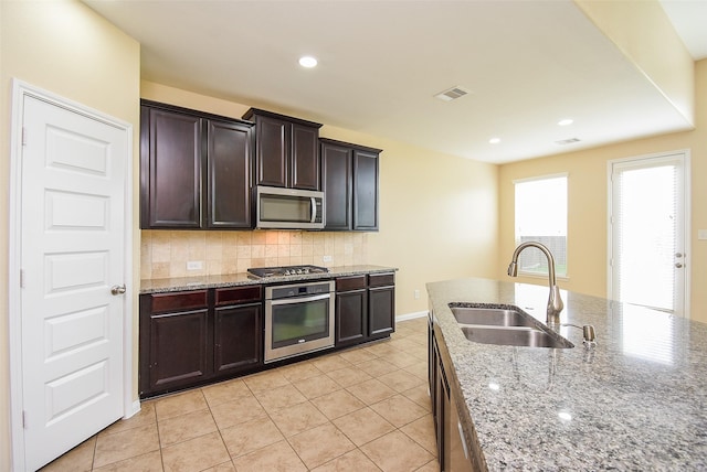 20315 Cypress Poll Dr, Cypress, TX 77433 - kitchen featuring stainless steel appliances, tasteful backsplash, light tile patterned floors, light stone countertops, and recessed lighting
