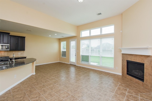 20315 Cypress Poll Dr, Cypress, TX 77433 - unfurnished living room featuring a tile fireplace, recessed lighting, and light tile patterned floors