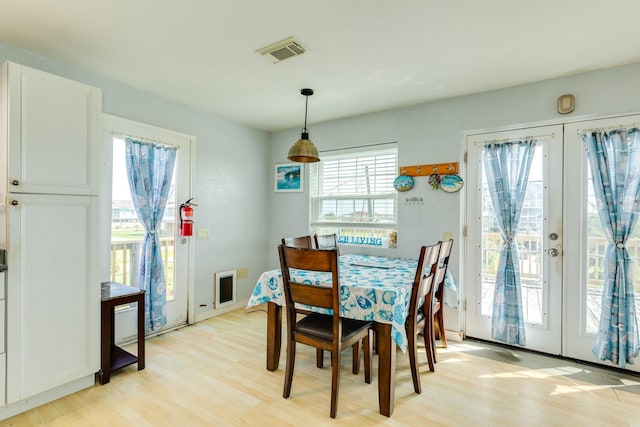 430 Jettyview Rd, Surfside Beach, TX 77541 - dining room with light wood-style flooring, french doors, and heating unit