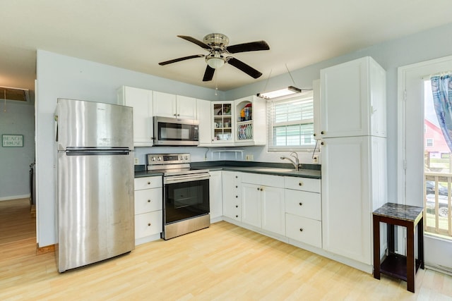430 Jettyview Rd, Surfside Beach, TX 77541 - kitchen featuring appliances with stainless steel finishes, dark countertops, light wood-type flooring, and ceiling fan