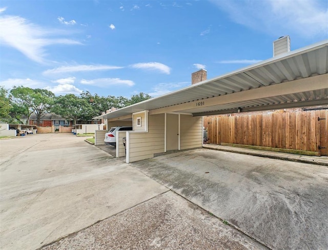 1691 W Sam Houston Pkwy S, Houston, TX 77042 - view of home's exterior featuring covered parking and a chimney