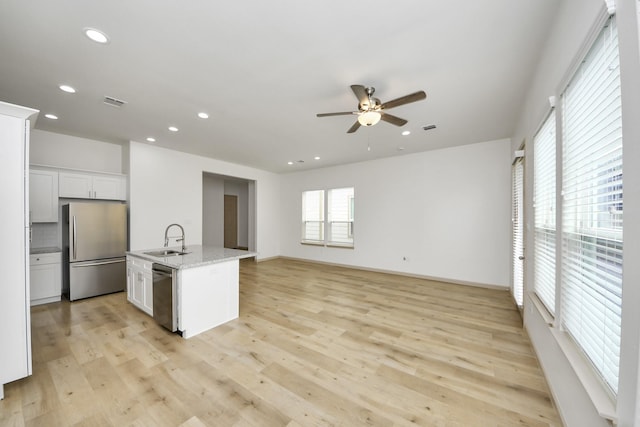 2119 Esther Dr, Houston, TX 77088 - kitchen featuring stainless steel appliances, ceiling fan, recessed lighting, light wood finished floors, and white cabinets