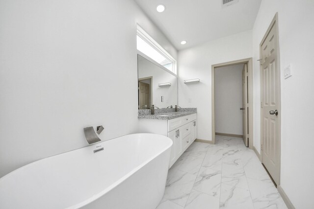 2119 Esther Dr, Houston, TX 77088 - bathroom with a soaking tub, double vanity, marble look tile flooring, and recessed lighting