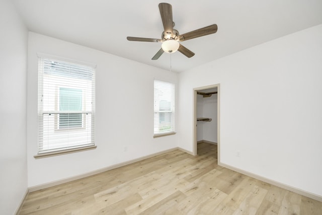 2119 Esther Dr, Houston, TX 77088 - unfurnished bedroom featuring light wood-style flooring, a walk in closet, and ceiling fan