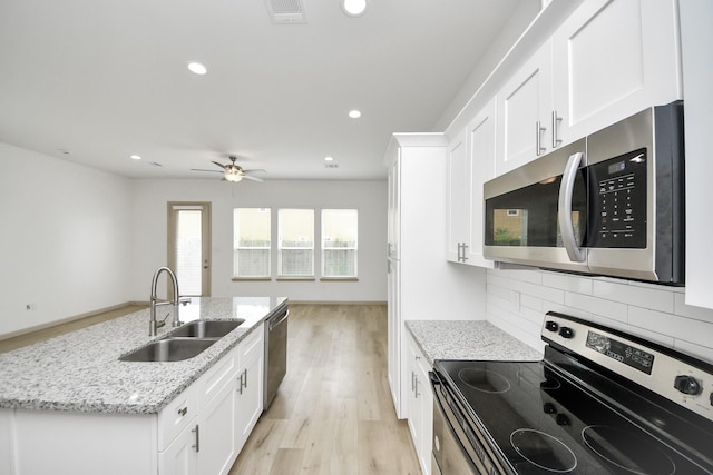 2119 Esther Dr, Houston, TX 77088 - kitchen featuring appliances with stainless steel finishes, light wood-type flooring, white cabinets, recessed lighting, and light stone countertops