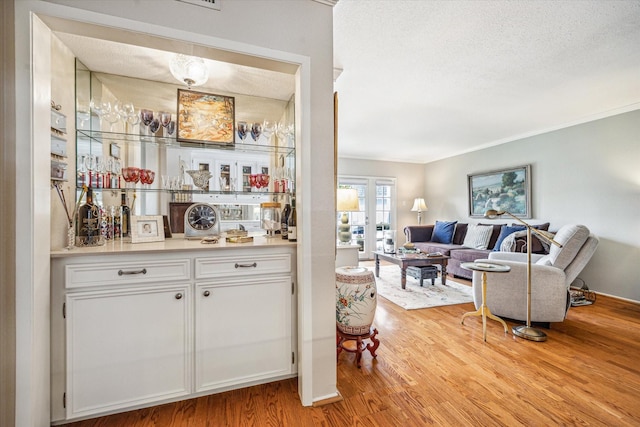 2238 S Piney Point Rd Unit 204, Houston, TX 77063 - indoor dry bar with light wood-style flooring, a textured ceiling, and crown molding
