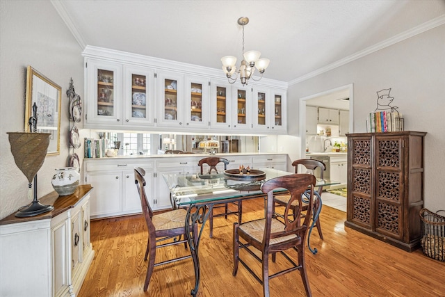 2238 S Piney Point Rd Unit 204, Houston, TX 77063 - dining space featuring ornamental molding, light wood-type flooring, and a chandelier
