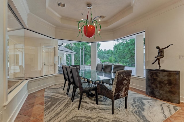 134 Trinity Oaks Ct, The Woodlands, TX 77381 - dining area featuring ornamental molding, a tray ceiling, and a chandelier