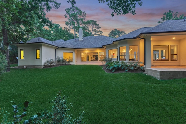 134 Trinity Oaks Ct, The Woodlands, TX 77381 - rear view of house featuring a chimney, a lawn, and stucco siding