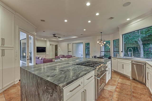 134 Trinity Oaks Ct, The Woodlands, TX 77381 - kitchen featuring stainless steel appliances, crown molding, recessed lighting, white cabinets, and dark stone countertops